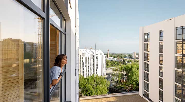 Femme penché à la fenêtre de son appartement